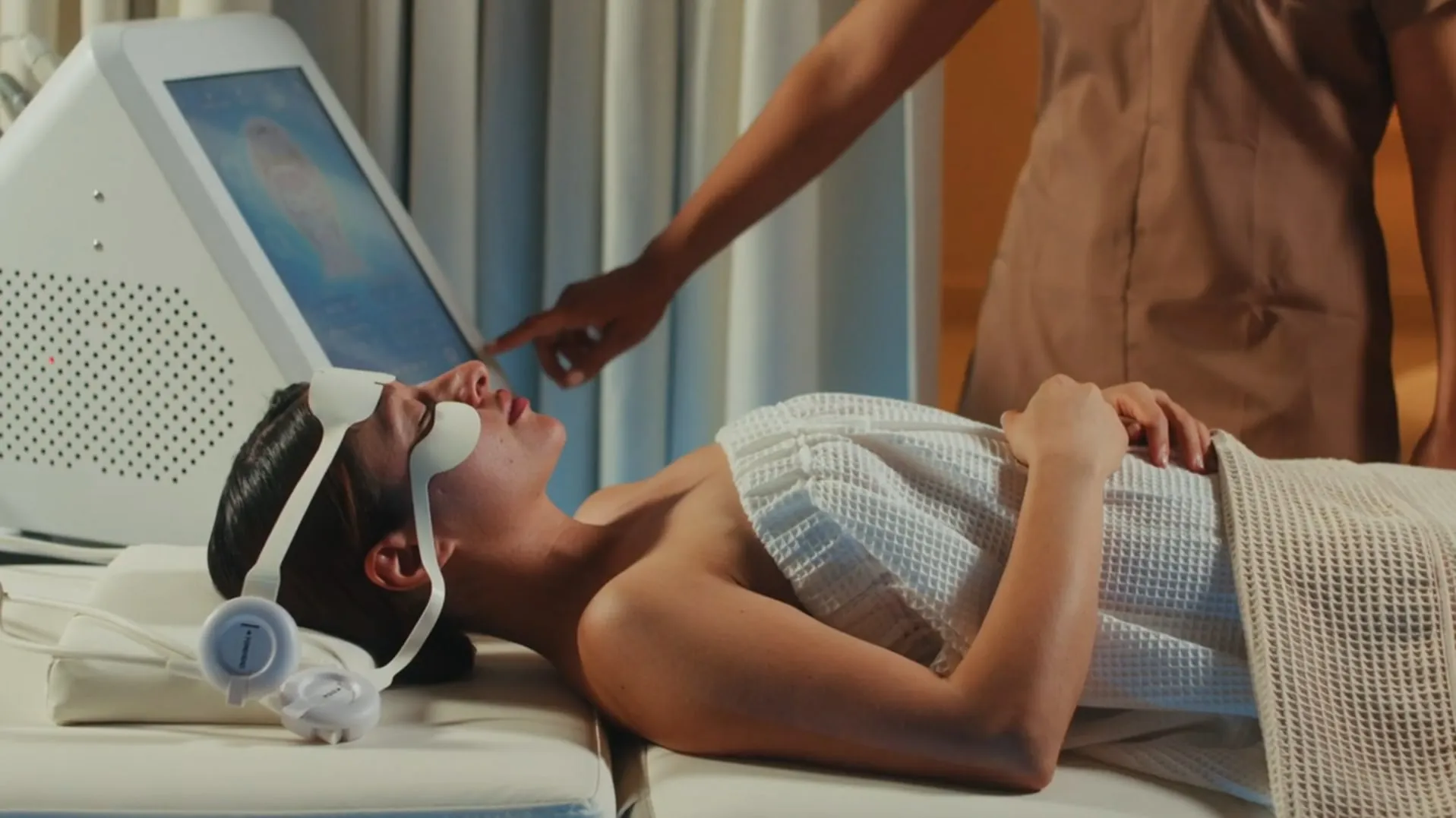 Facial electrostimulation mask, the therapist adjusting the screen