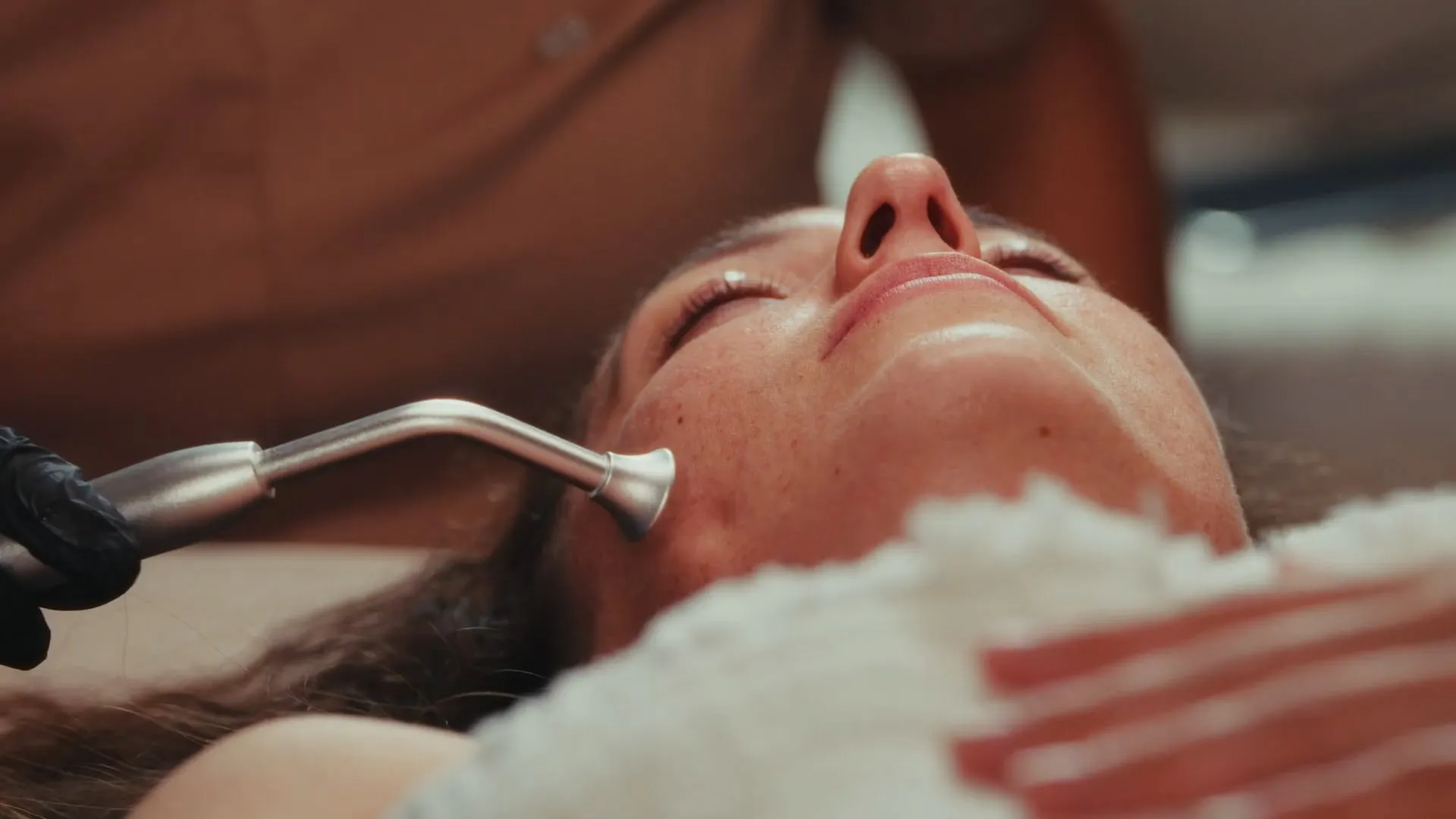 A silver wand traces the cheek during a facial at Santina
