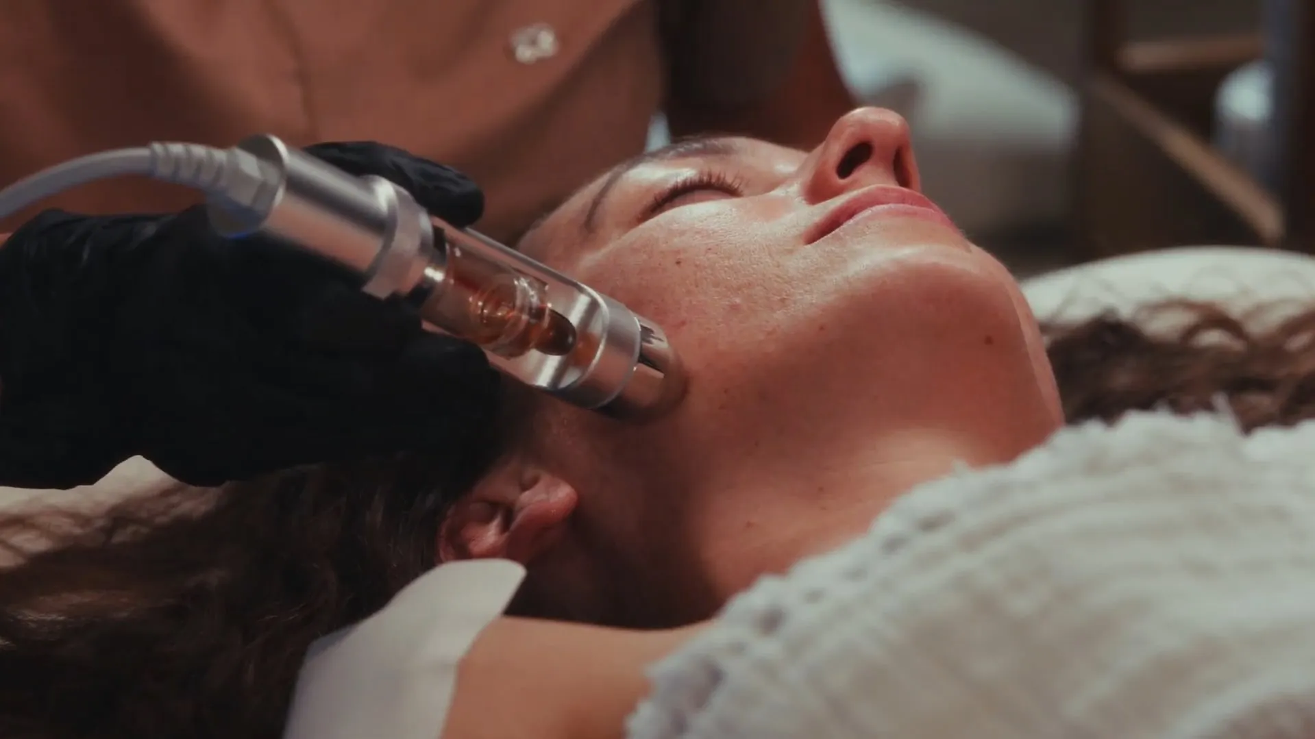 Mesotherapy applicator on the cheek in the aesthetic medicine room