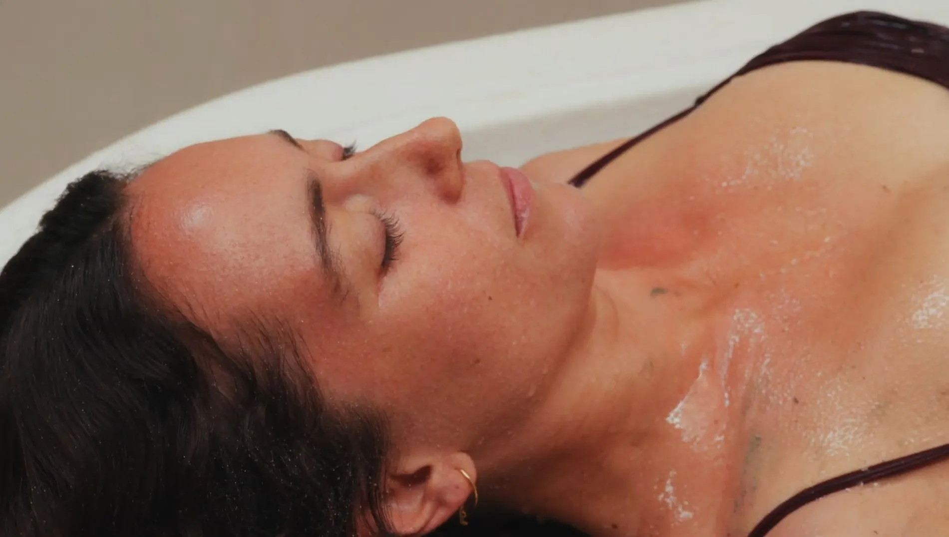 A guest’s face under the Vichy shower, skin wet, eyes closed